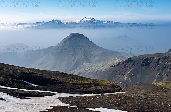 View of mountain peaks between fog