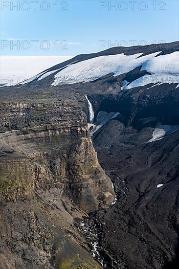 Gorge of volcanic stone with waterfall