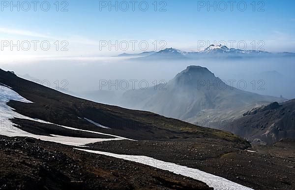 View of mountain peaks between fog