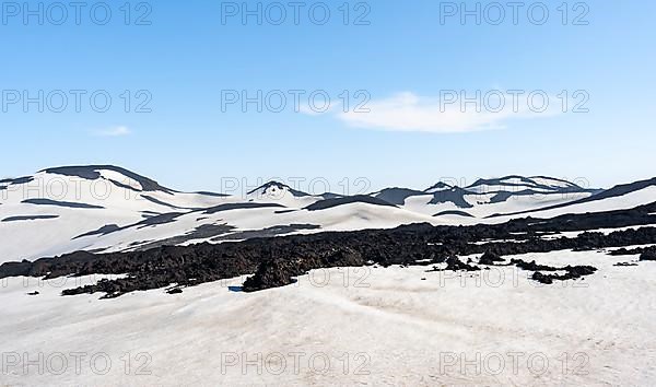 Barren hilly volcanic landscape of snow and volcanic rock