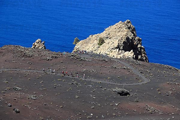 Hikers on the way from the volcano San Antonio to the volcano Teneguia at Cap Fuencaliente