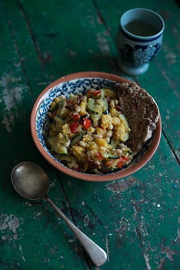 Vegan dish with a cup of wine on a rustic wooden table