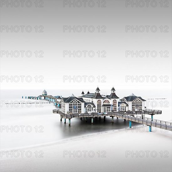 The famous pier in Sellin in the fog on the Baltic Sea beach of Ruegen