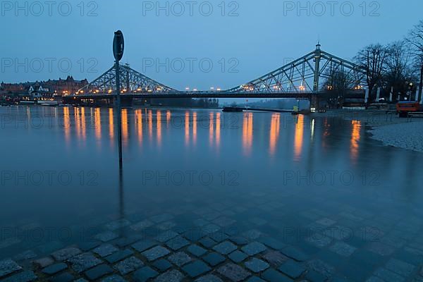 High water in winter on the Elbe at the illuminated Blue Wonder