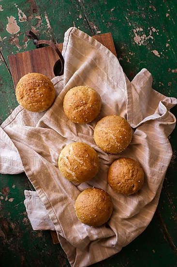 Freshly baked round rolls on tea towel