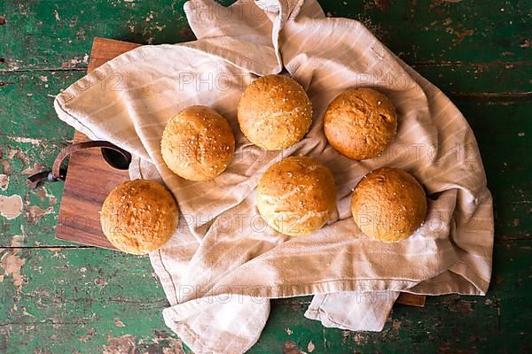 Freshly baked round rolls on tea towel