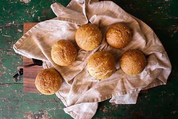 Freshly baked round rolls on tea towel