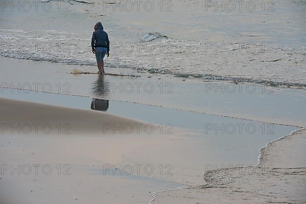 Fisherman walking along the beach