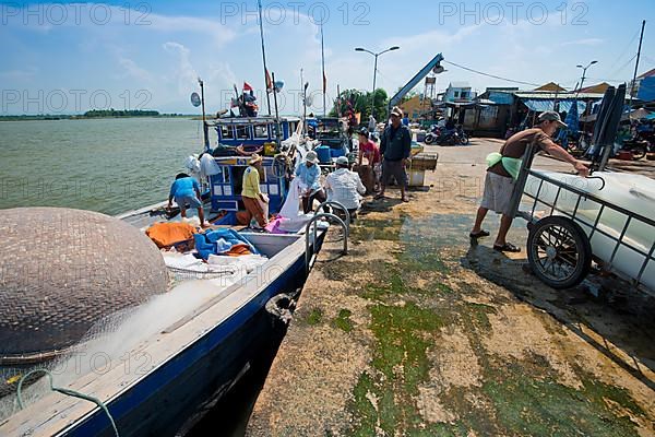 Small fishing pier on the Thu Bon River where a fishing boat is unloaded