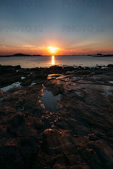 Rocks on the beach of Port Blanc in the evening light