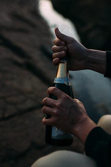 Opening a bottle of champagne on the beach