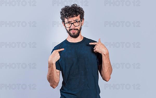 Man with puzzled face pointing at himself, person with confused gesture pointing at himself. bewildered people pointing to self