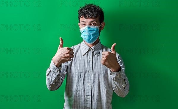 Isolated man with mask on giving thumbs up, Person giving thumbs up with mask on isolated. Concept of the correct use of the surgical mask