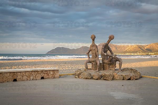 Sculptures by Joan Bennassar on beach promenade with sandy beach Playa Sa Canova in Son Serra de Marina, Serres de Llevant mountains in the back