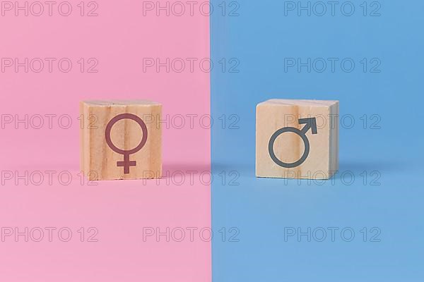 Gender stereotypes showing cubes with male and female signs on pink and blue background,