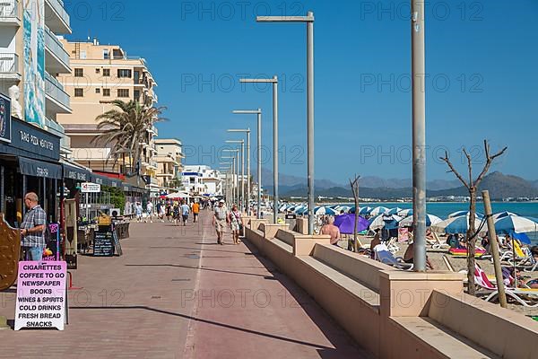 Beach promenade with sandy beach sun loungers and parasols, Can Picafort