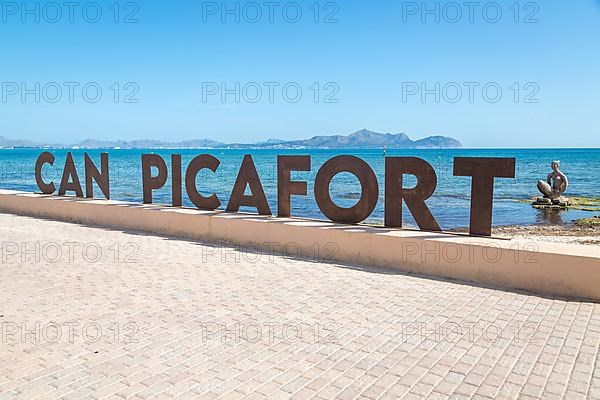 Beach promenade with Can Picafort lettering, sculpture by Joan Bennassar in the back