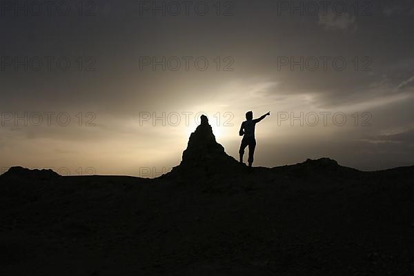 A tourist points to the sky near Ait Ben Haddou, Morocco