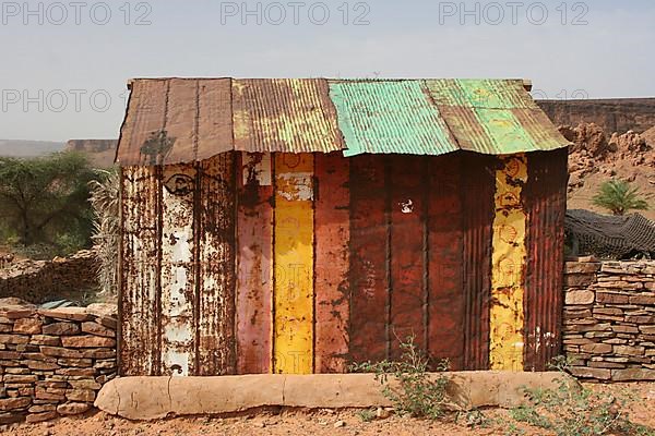 Shack assembled from unrolled tin barrels, seen in Terjit