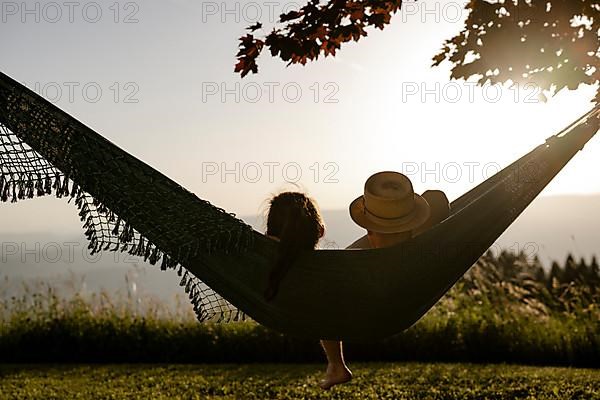 Couple lying in a hammock at sunset, Carinthia