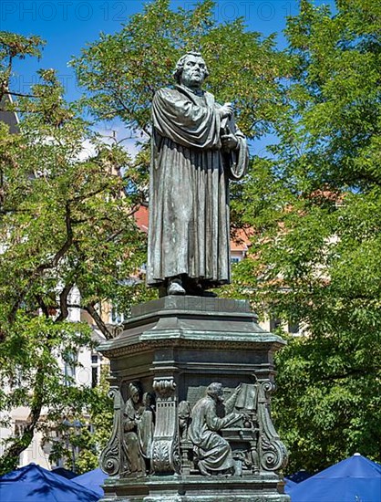 Luther monument by the sculptor Adolf von Donndorf from 1895 on Karlsplatz in Eisenach. The plinth motif shows Luther on the right in his study room at Wartburg Castle and on the left as a boy with the Cotta family in Eisenach. The reformer Martin Luther,