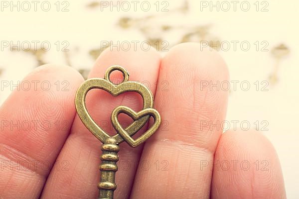 Hand and retro style metal keys on a white background,