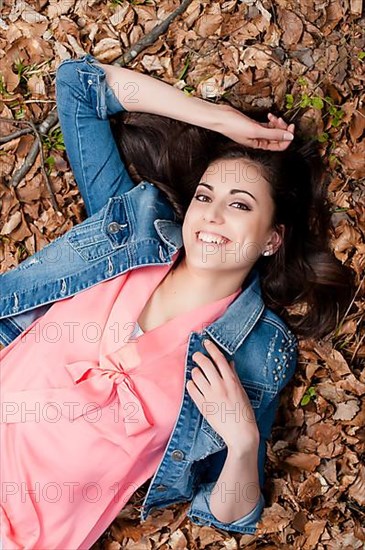 Young woman lying on the forest floor,