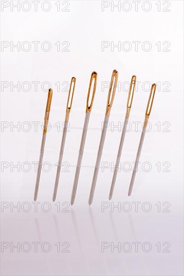 Six different sewing needles isolated on a white background,