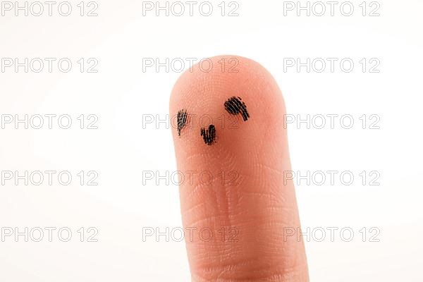 Black dots forming a face on the fingertip,