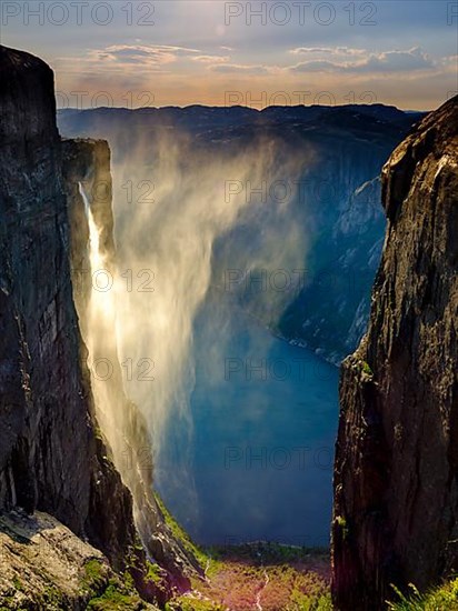 Waterfall cascades over the rocks of Kjerag into the Lysefjord and is blown away by the wind, Lyseboten