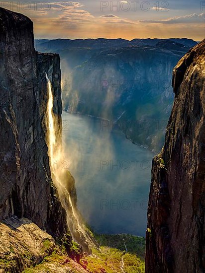 Waterfall cascades over the rocks of Kjerag into the Lysefjord and is blown away by the wind, Lyseboten