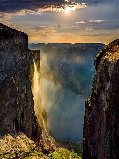 Waterfall cascades over the rocks of Kjerag into the Lysefjord and is blown away by the wind, Lyseboten