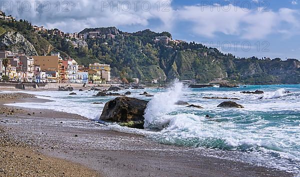 Sea surf in front of the promenade with Taormina on the hill, Giardini-Naxos