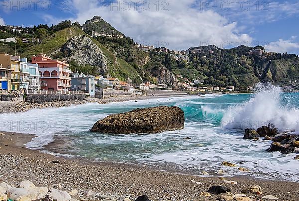 Sea surf in front of the promenade with Taormina on the hill, Giardini-Naxos