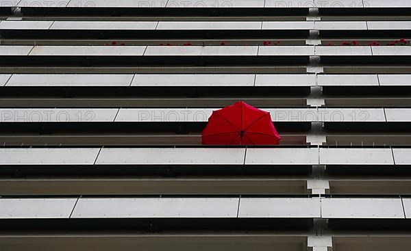 Red parasol on the balcony of a high-rise building in Marzahn, Berlin