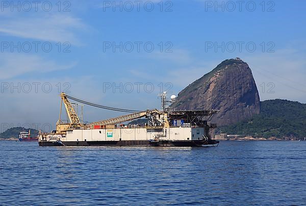 Dredger in the bay. Baia de Guanbara Bay in the east of Rio de Janeiro, with a view of Sugar Loaf Mountain