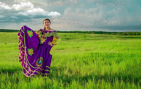 Portrait of Nicaraguan young woman in traditional folk costume in the field, Nicaraguan woman in traditional folk costume in the field grass
