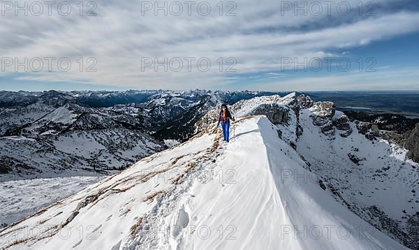 Climber on a rocky snowy ridge, hiking trail to Ammergauer Hochplatte