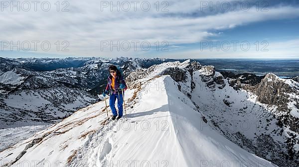 Climber on a rocky snowy ridge, hiking trail to Ammergauer Hochplatte