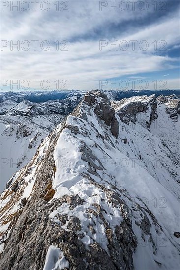 Rocky snow-covered mountain ridge of the Ammergauer Hochplatte, behind peak Kraehe