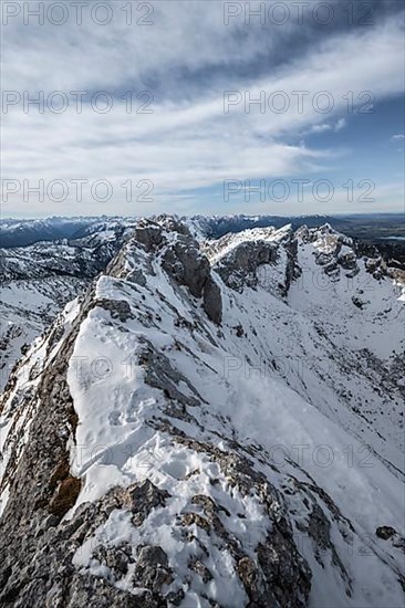 Rocky snow-covered mountain ridge of the Ammergauer Hochplatte, behind peak Kraehe