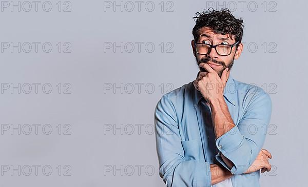 Handsome man wondering with hand on chin looking aside isolated, Person wondering with hand on chin seeing blank space