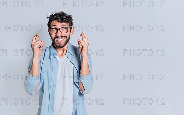 Concept of positive person making a wish and crossing his fingers on isolated background. Positive people smiling making a wish while crossing his fingers. Happy man making a wish crossing his fingers,