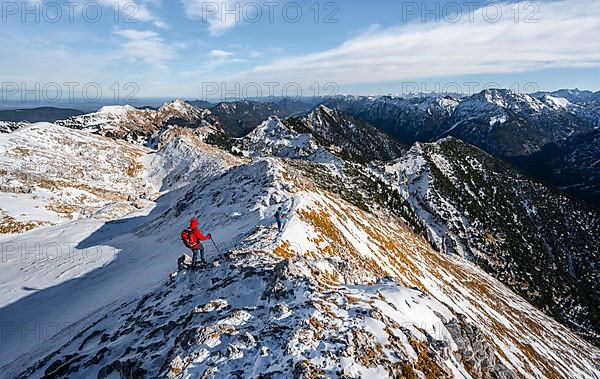 Two climbers on the narrow rocky snowy ridge of the Ammergauer Hochplatte, view towards Loesertaljoch