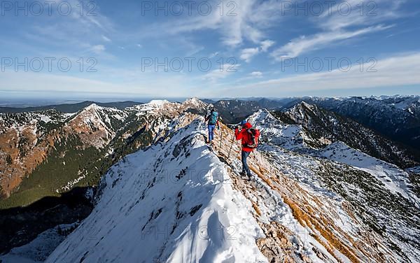 Two mountaineers on the rocky snowy ridge of the Ammergauer Hochplatte, view towards Loesertaljoch