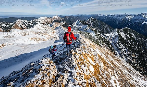 Two mountaineers on the narrow rocky snowy ridge of the Ammergauer Hochplatte, view towards Loesertaljoch