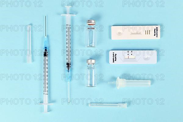 Rapid antigen test and vaccine vials with syringes. Tools to fight Corona Virus pandemic,