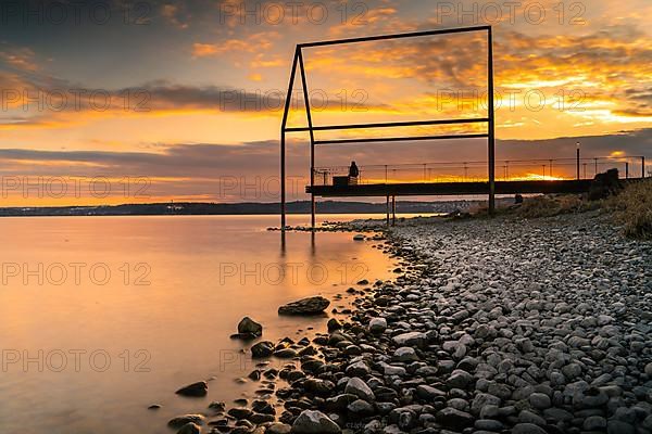 Sunset jetty on the stone beach in Unteruhldingen on Lake Constance, Germany