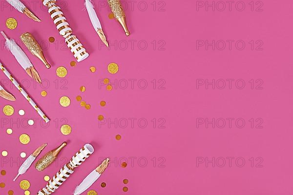 Party flat lay with golden and white decoration like confetti and feathers on pink background with copy space,