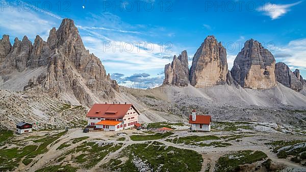 View of mountain hut Dreizinnenhuette and chapel with rock massif Paternkofel and mountain range drei Zinnen, panorama